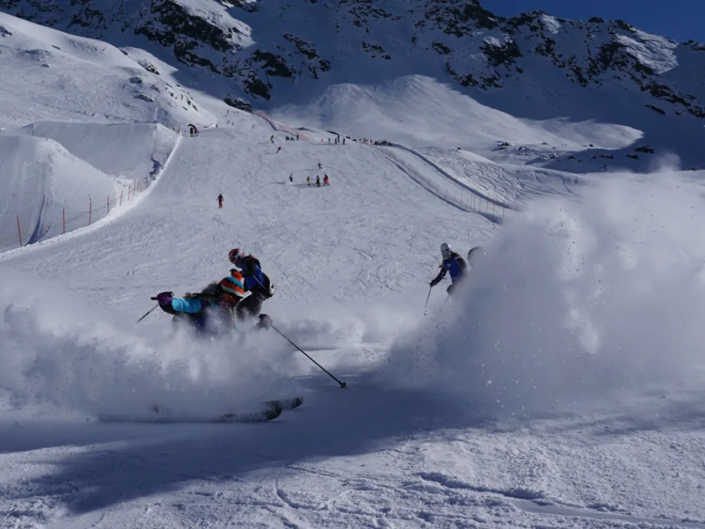 Skifahrende ziehen ihre Spuren über den Hang.